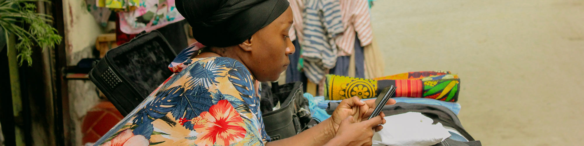 Woman in a colorful dress typing on her smartphone