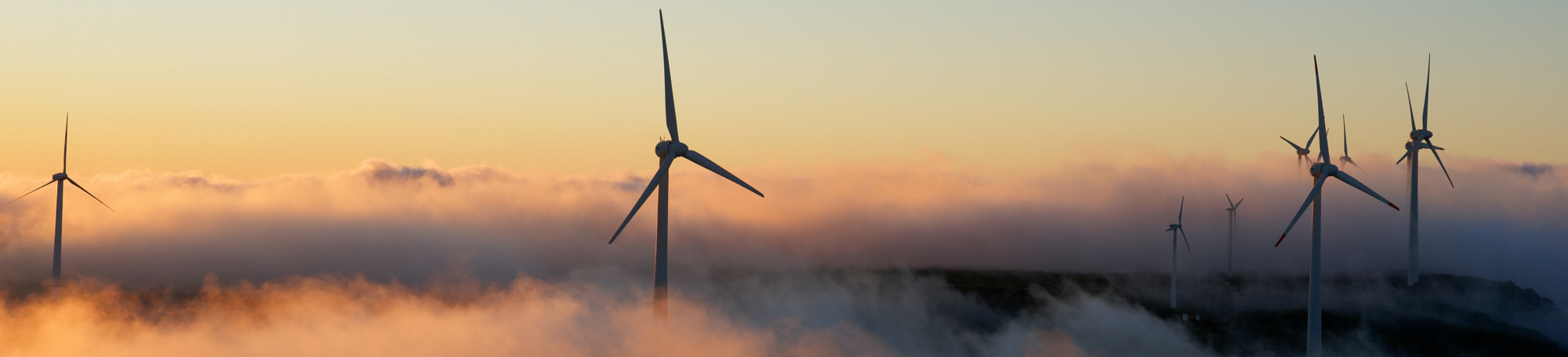 Windmills in a cloudy and hilly environment