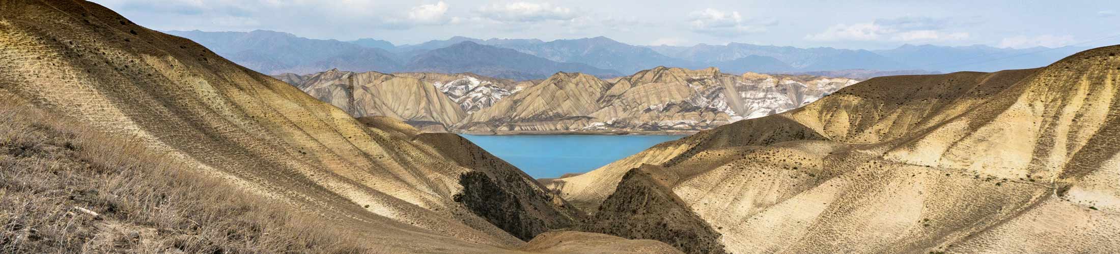 A mountain landscape offers a view of a blue lake