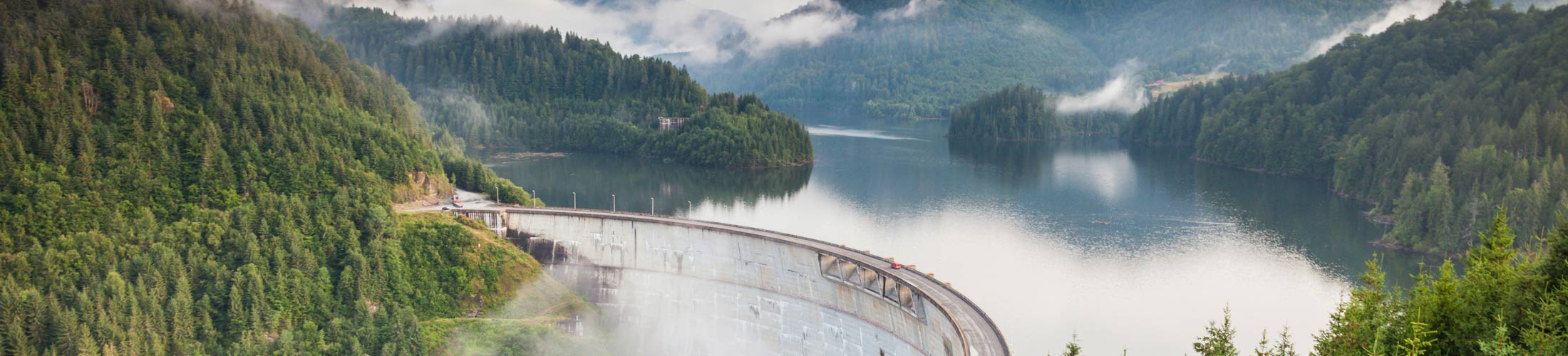 A dam in a forest landscape with veil clouds