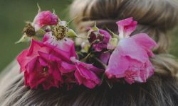 A little girl's blonde hair with pink roses in them